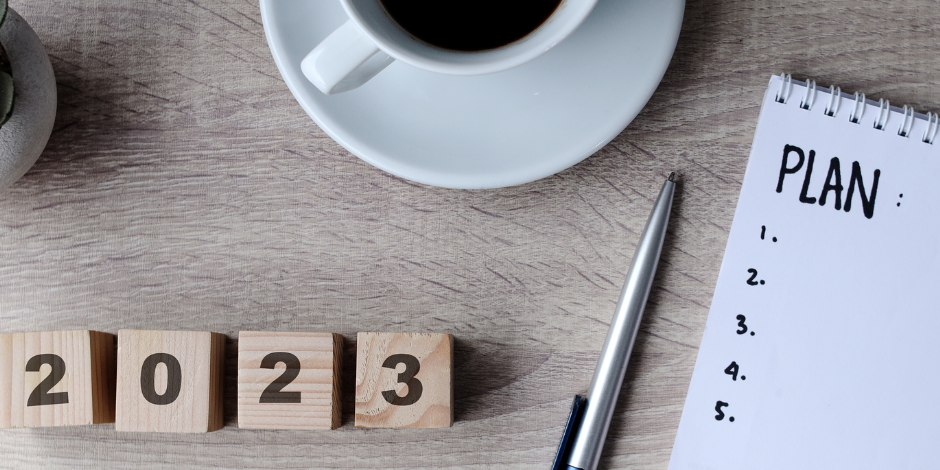an image of a coffee cup, a notepad with a plan and 2023 calendar