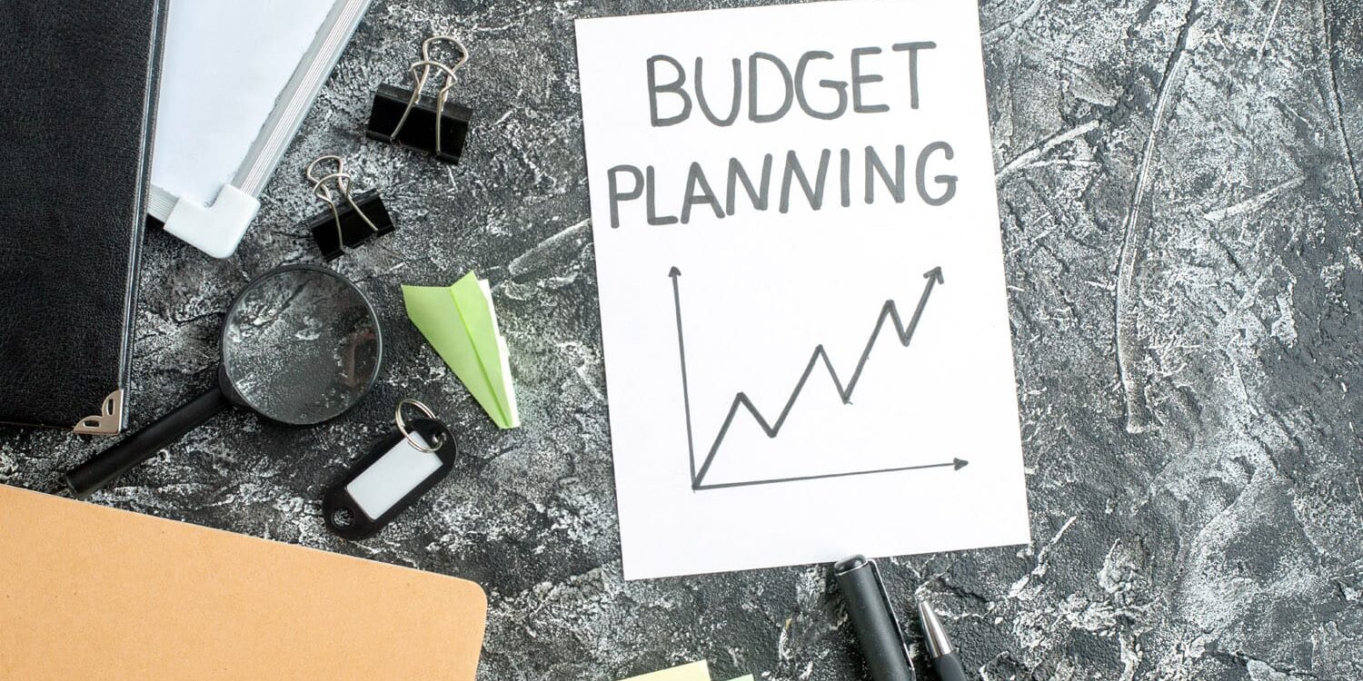 top view budget planning note with pens on gray background job c